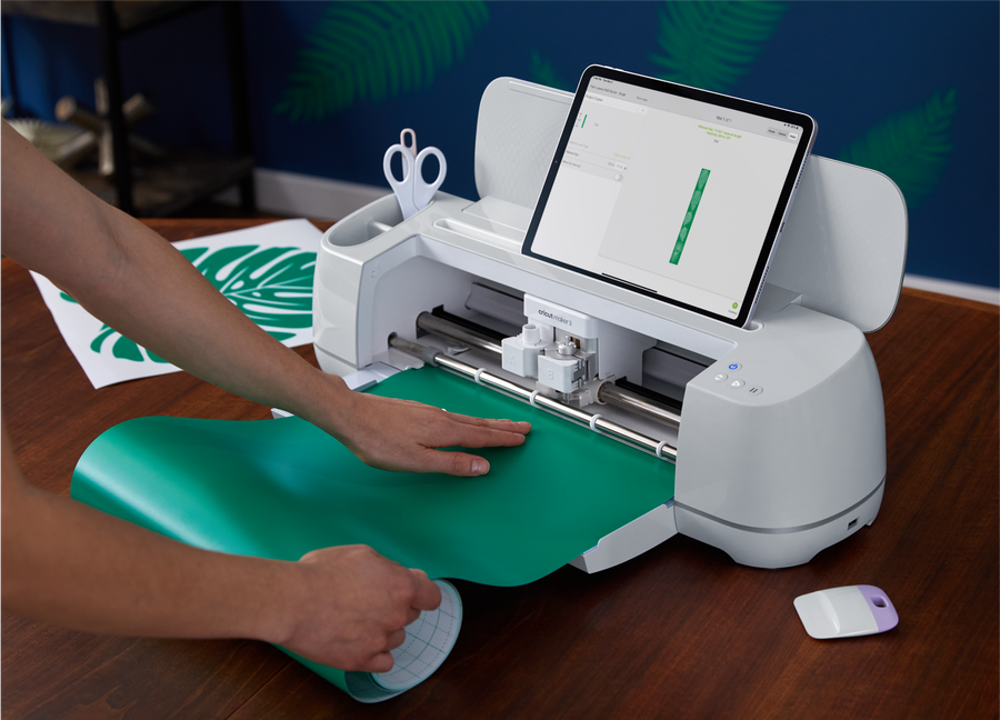Hands adding paper into Cricut printing device
