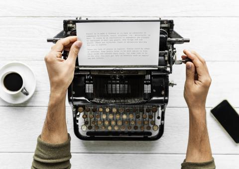 Aerial view of man typing at retro typewriter