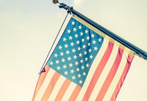 American flag on a flagpole with daylight shining through