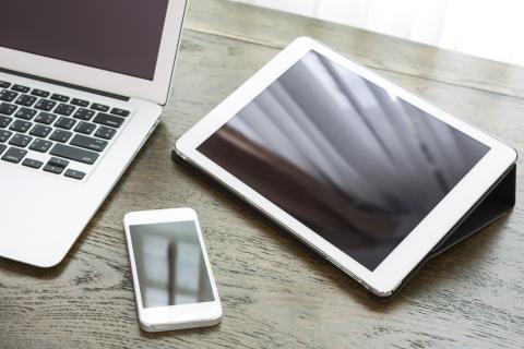 Laptop, iPad, and iPhone on desk