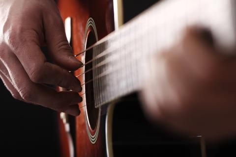 Close-up of a hand strumming a guitar