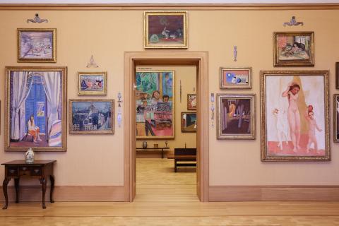 Barnes Foundation internal architecture, showcasing a tan wall with an open doorway surrounded by expressionist paintings 