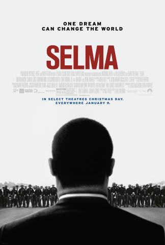 Movie poster for 2014's "Selma," featuring a black-and-white image of the back of a man from the shoulders up wearing a dark suit with dark hair, standing before a barricade of threatening police officers in helmets and uniform