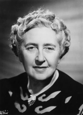 Black-and-white portrait of author Agatha Christie viewed from the collar up, staring directly into the camera with a piercing gaze