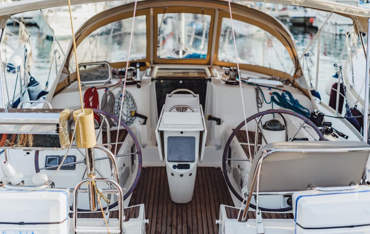 Photograph of the interior cockpit to a personal yacht parked in a shared harbor.